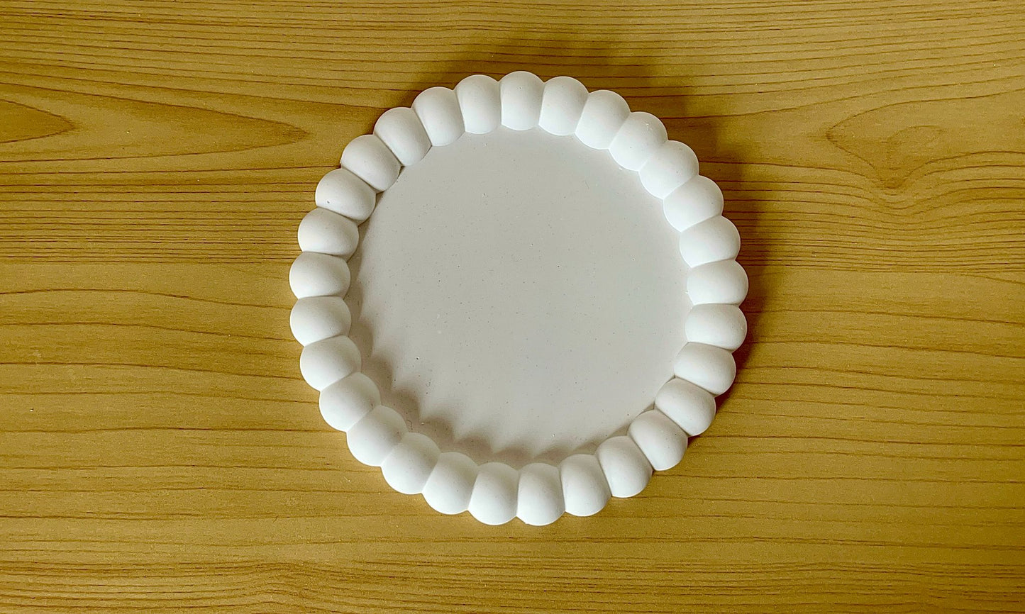 Vista cenital de la bandeja redonda de burbujas 'B', resaltando su diseño circular y relieve de esferas alrededor del borde