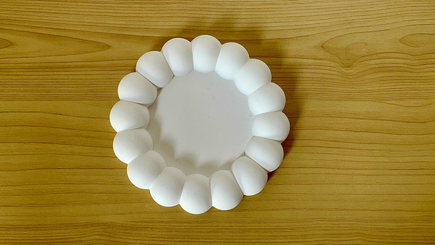 Vista superior de la bandeja redonda de burbujas 'A' vacía, mostrando su forma circular y textura en relieve de esferas