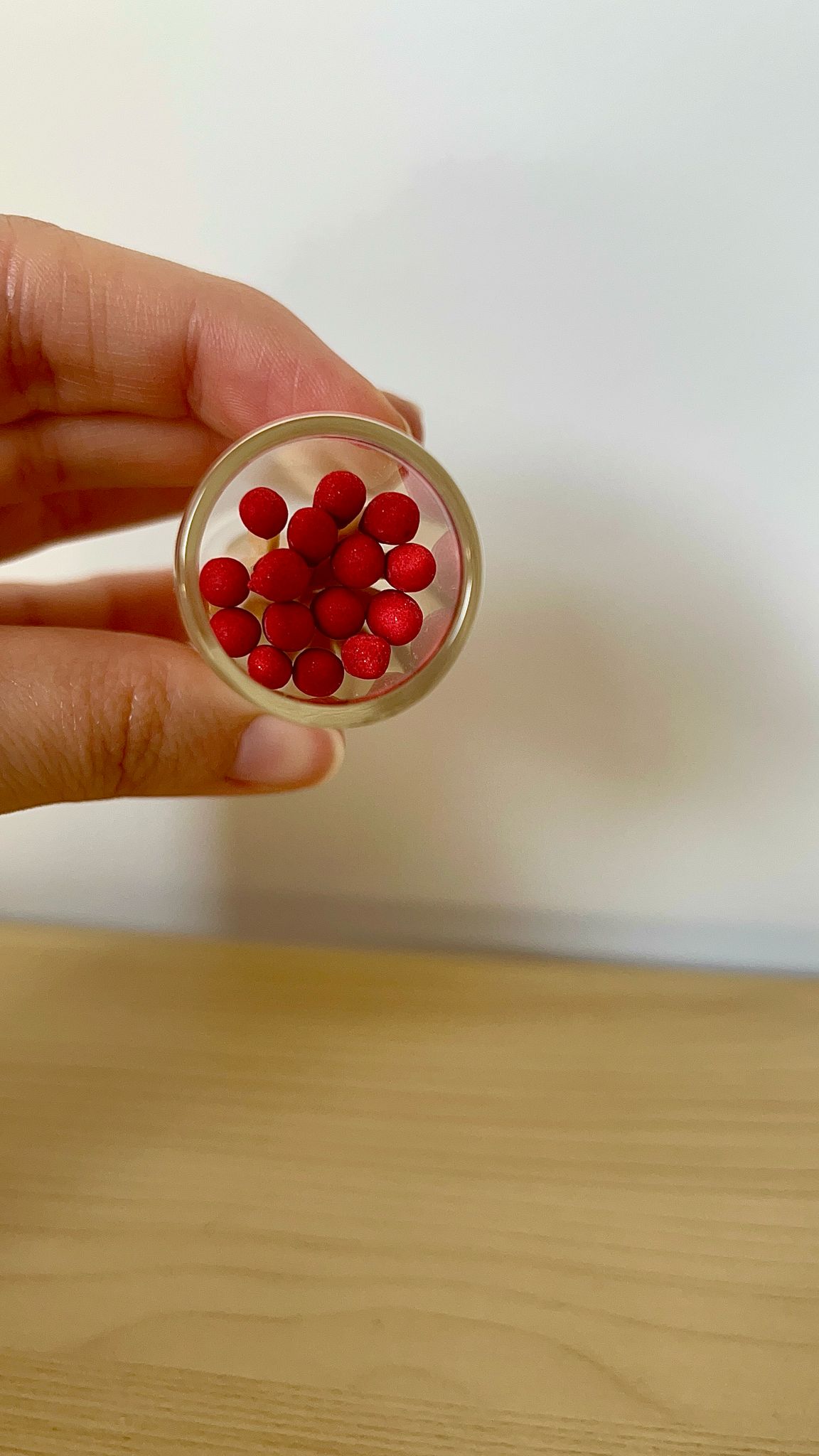 Porta fósforos de cristal de pie con tapón retirado, mostrando los fósforos rojos visibles en su interior