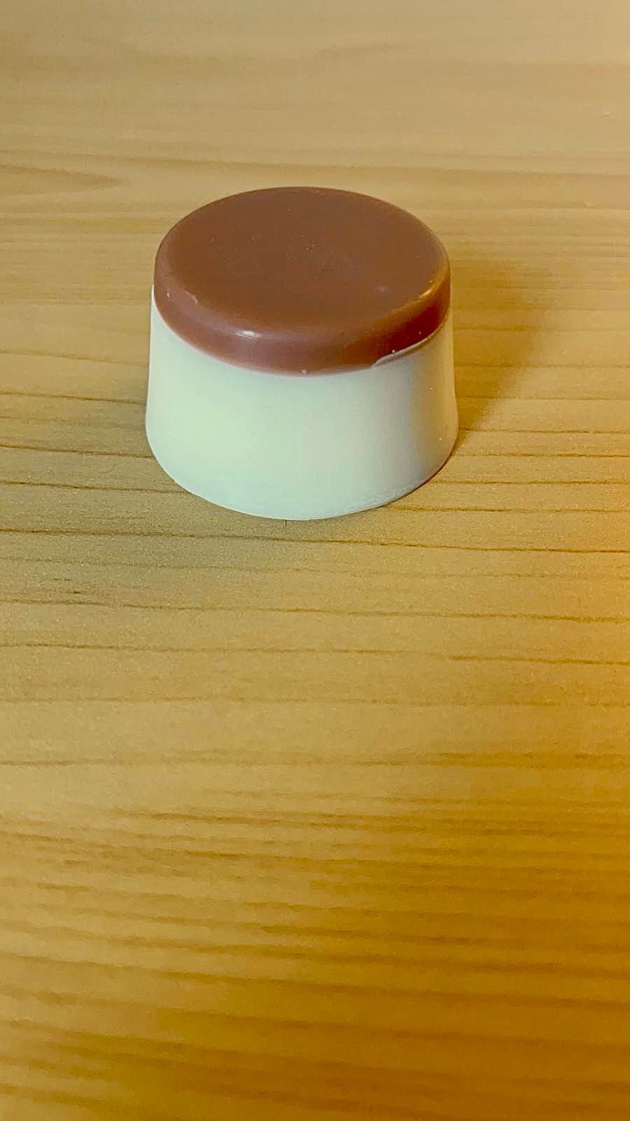 Melt aromático de cera de soja en tono crema con parte superior color café, colocado sobre superficie de madera